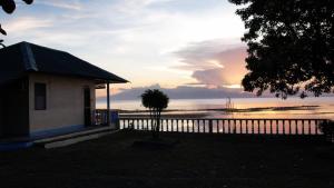 a house with a fence in front of the ocean at Karlsson's Guesthouse in Larena