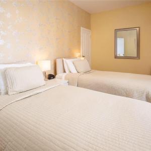 a bedroom with two beds and a mirror on the wall at Hillcrest Bed & Breakfast in Eyemouth