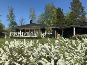 ein Haus mit weißen Blumen davor in der Unterkunft Backahusets B&B in Höör