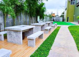 una fila de mesas y bancos en un parque en Arthomes BB6, en Mandaue