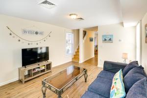 ein Wohnzimmer mit einem blauen Sofa und einem TV in der Unterkunft Milford Vacation Rental Steps to the Beach! in Milford