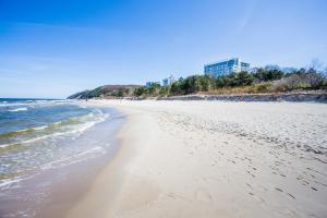 a view of the beach with buildings in the background at Apartamenty Promenada Gwiazd 28 - visitopl in Międzyzdroje