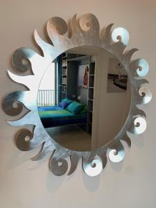 - un miroir mural avec un lit dans la chambre dans l'établissement Casa Nausica, à Aci Trezza