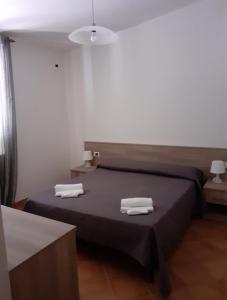 1 dormitorio con 1 cama con toallas en Parco Meridiana, en Scalea