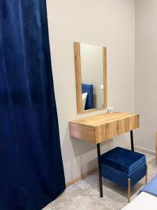 a dressing table with a mirror and a blue stool at Sapphire home in Ixia