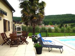 d'une terrasse avec une table et des chaises à côté de la piscine. dans l'établissement Charmante Maison à Vézac au cœur des 5 Châteaux en Dordogne, à Vézac