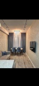 salon z kanapą, stołem i telewizorem w obiekcie Milaya kvartira w mieście Baku