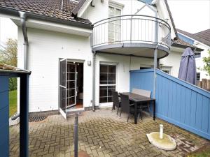 patio ze stołem i balkonem w domu w obiekcie Haus Regenbogen w Zingst