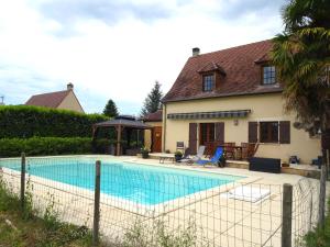 - une piscine en face d'une maison dans l'établissement Charmante Maison à Vézac au cœur des 5 Châteaux en Dordogne, à Vézac