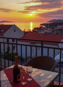 a bottle of wine sitting on a table with two wine glasses at Apartments Viskovic in Hvar