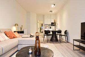 sala de estar con sofá y mesa en Miramar Residences - Luxurious Seaside Apartments, en Blankenberge