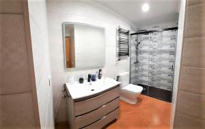 a bathroom with a sink and a toilet and a mirror at Apartamento Peonia 1 in Canet de Berenguer +27 photos