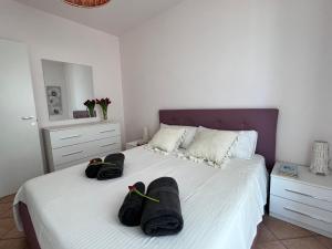 een slaapkamer met een bed met twee zwarte zakken erop bij Apartment SunShine in Marzamemi