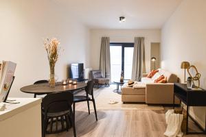 sala de estar con mesa y sofá en Miramar Residences - Luxurious Seaside Apartments, en Blankenberge