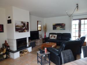 a living room with a couch and a fireplace at Charmante Maison à Vézac au cœur des 5 Châteaux en Dordogne in Vézac