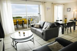 a living room with a couch and a table at Duplex de 100m2 avec 3 chambres vue mer in Royan