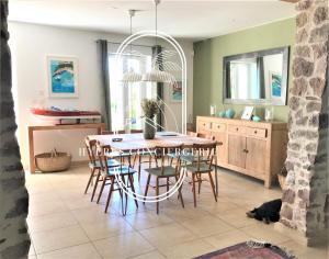 uma cozinha e sala de jantar com mesa e cadeiras em Mas Aquarelle, vieux mas en pierres avec piscine em Hyères