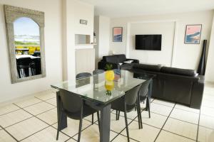 - une salle à manger et un salon avec une table et des chaises en verre dans l'établissement Duplex de 100m2 avec 3 chambres vue mer, à Royan