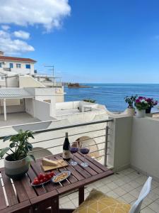 een tafel met twee glazen wijn op een balkon bij Apartment SunShine in Marzamemi