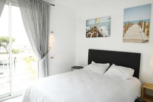 a bedroom with a white bed and a large window at Duplex de 100m2 avec 3 chambres vue mer in Royan