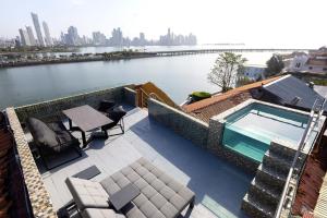 a swimming pool on top of a building next to a river at AmazINN Places Penthouse Deluxe, Skyline and Private Rooftop in Panama City