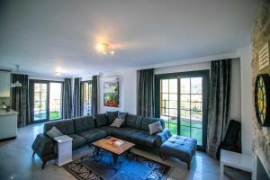 uma sala de estar com um sofá e uma mesa em DADYA VİLLA 4 - Marmaris Turgut da özel havuzlu denize yakın lüks villa em Marmaris