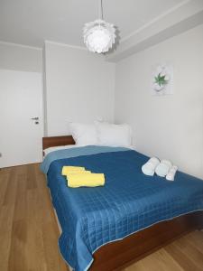 a bedroom with a blue bed with towels on it at Przystanek Centrum in Gdynia