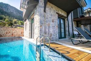 uma casa com piscina ao lado de um edifício em DADYA VİLLA 4 - Marmaris Turgut da özel havuzlu denize yakın lüks villa em Marmaris