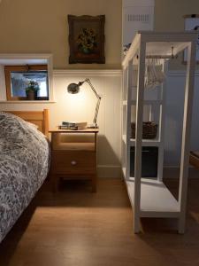 Gîte Maison du Trottoir, Sussac في Sussac: غرفة نوم مع سرير بطابقين ومكتب مع مصباح