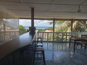 eine Bar mit Hockern und Meerblick in der Unterkunft le moringa Appart vue mer 360 Mamoudzou hyper centre in Mamoudzou