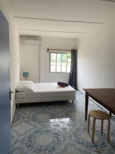 1 dormitorio con cama, mesa y escritorio en le moringa Appart vue mer 360 Mamoudzou hyper centre en Mamoudzou