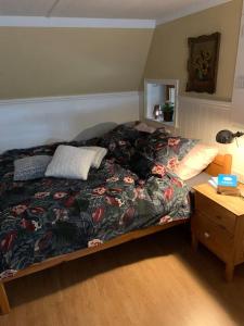 Gîte Maison du Trottoir, Sussac في Sussac: غرفة نوم مع سرير مع لحاف من الزهور وطاولة