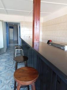 une rangée de tabourets à un bar dans une pièce dans l'établissement le moringa Appart vue mer 360 Mamoudzou hyper centre, à Mamoudzou
