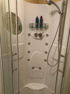 eine Dusche mit Glastür im Bad in der Unterkunft Gîte Maison du Trottoir, Sussac in Sussac
