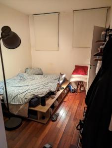 een slaapkamer met een bed en een houten vloer bij chambre canal st martin in Parijs