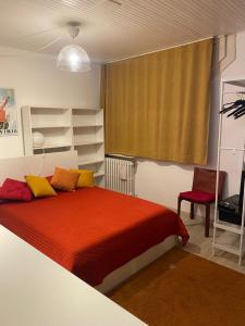 ein Schlafzimmer mit einem Bett mit einer roten Decke und gelben Kissen in der Unterkunft Al Naviglio in Dolo