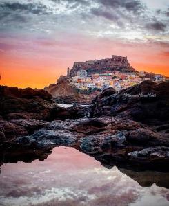 una città in cima a una montagna con un corpo d'acqua di B&B Dal Duca Enrico a Castelsardo