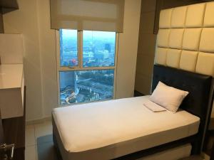 łóżko w pokoju z dużym oknem w obiekcie Central Park Apt. 3 Bedroom (42nd Floor - Alaina) w Dżakarcie