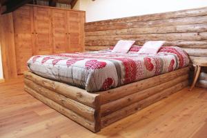 Una cama hecha de troncos en una habitación en Attic in the centre of Asiago, en Asiago