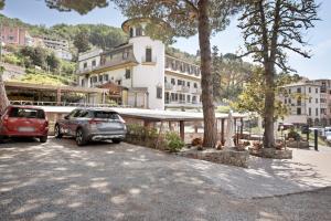 two cars parked in a parking lot in front of a building at Appartamento Monolocale Moneglia 35 in Moneglia