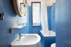a blue bathroom with a sink and a mirror at Appartamento Monolocale Moneglia 35 in Moneglia +16 photos