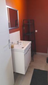 een badkamer met een witte wastafel en een spiegel bij Le Chant des Cigales in Le Cailar