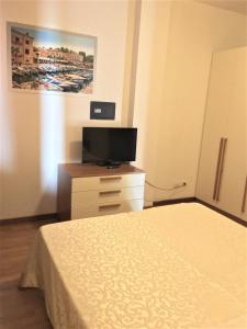 sypialnia z łóżkiem i telewizorem na komodzie w obiekcie Verona Class ApartHotel "Residenze del Cuore" w Weronie