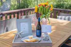 a table with a bottle of wine and a vase of flowers at 3835 Molly's Cove home in Pebble Beach