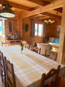 uma sala de jantar com uma mesa e cadeiras num camarote em Chalet de 3 chambres avec piscine partagee sauna et terrasse a Le Devoluy em Le Dévoluy