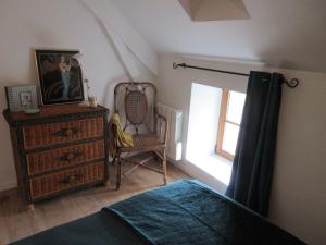 a bedroom with a bed and a dresser and a window at Maison de la Carrérie, gîte de charme à Calmont 12450 in Calmont