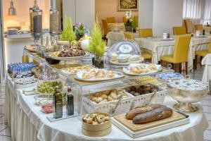 uma mesa de buffet com muitos tipos diferentes de alimentos em Hotel Terme Olympia em Montegrotto Terme