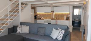 a living room with a blue couch and a kitchen at Loft Suites - by Avelink in Spata