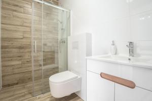 a bathroom with a shower and a toilet and a sink at Morski Piasek in Grzybowo +51 photos