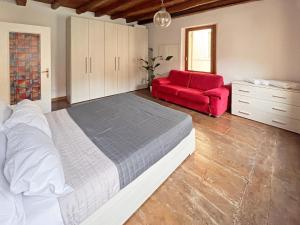 1 dormitorio con 1 cama grande y 1 silla roja en Pao Apartment - Castelvecchio, en Verona